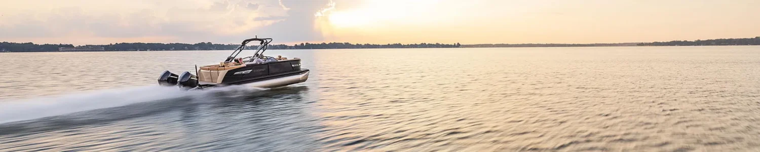 Pontoon boat cruising on a calm lake at sunset